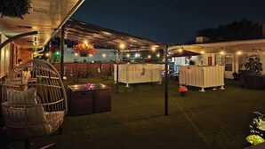 An outdoor patio area with a covered seating area, a pool table, and a bar area.