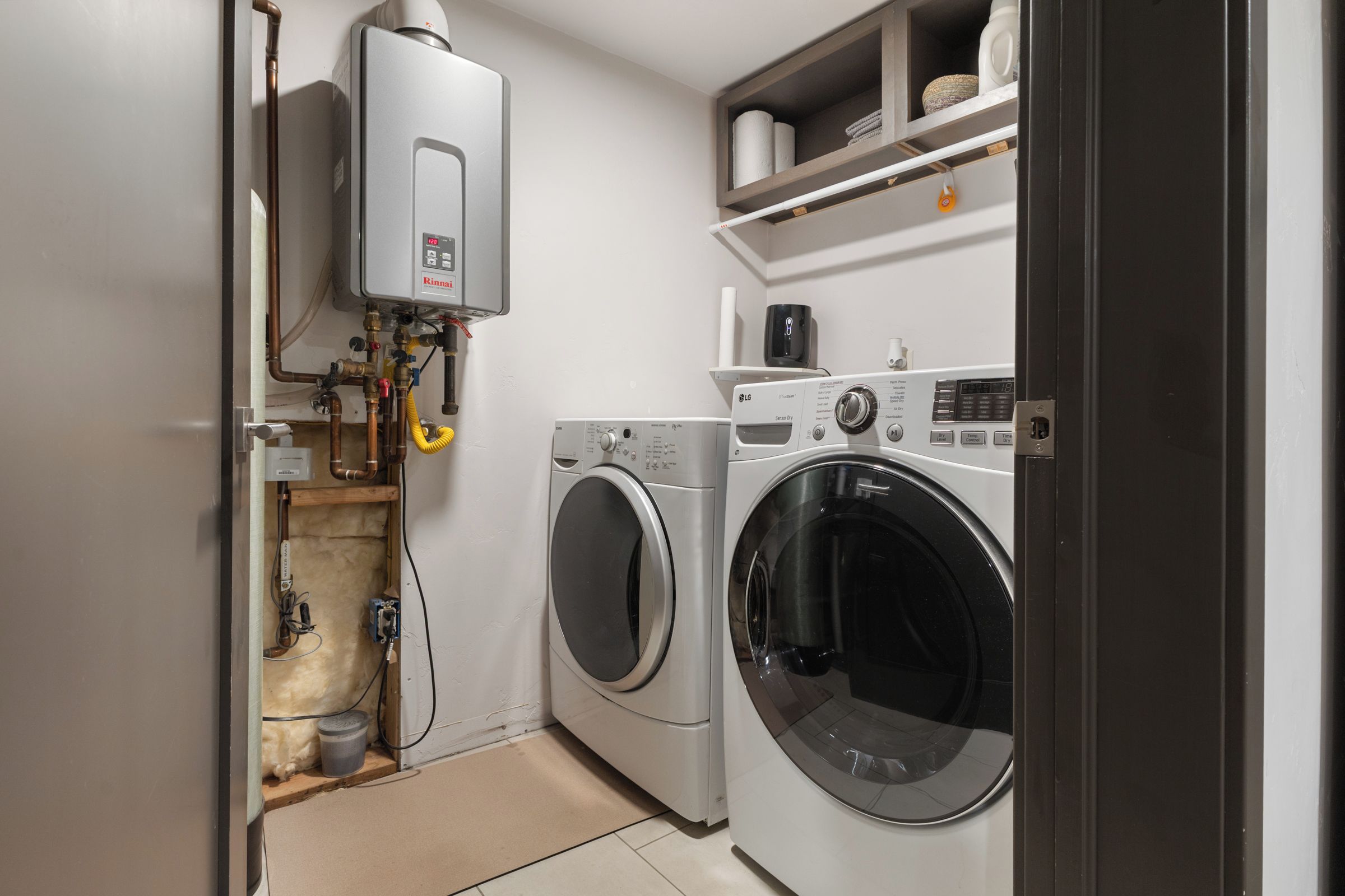A laundry room with a washing machine, dryer, and a water heater.