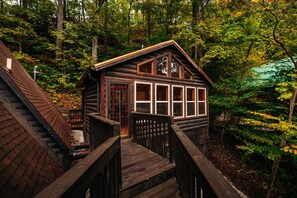 A log cabin with a wooden deck and a staircase leading to the entrance. - RRG cottage - cave fire pit, hot tub, & pool table (Stanton)