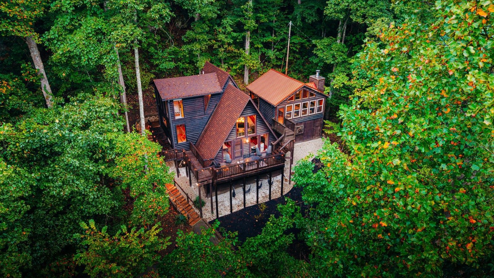 A cabin with a wooden deck and a small staircase leading to the entrance.