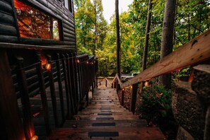 A wooden staircase leading to a cabin with a view of a forest. - RRG cottage - cave fire pit, hot tub, & pool table (Stanton)