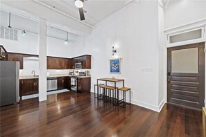 A modern kitchen with dark wooden cabinets, a central island, and a dining area with stools.