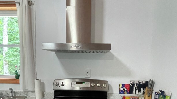 Una cocina con estufa de acero inoxidable, horno y cocina a gas empotrada.