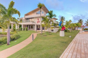 A modern hotel with a spacious outdoor area, including a pool and palm trees. - Beachfront Cap Cana Estate · Private Beach · Spa (Punta Cana)
