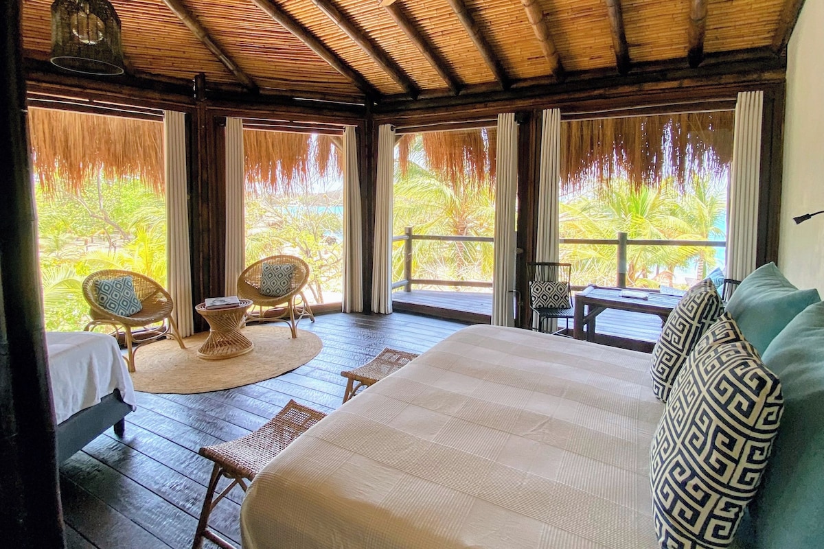 A room with a bed, a ceiling fan, and a view of the outdoors.