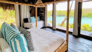 A room with a bed, a ceiling fan, and a view of the sea. - ENAI DEL MAR (Bolívar)