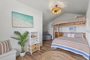 A bedroom with a bunk bed, a white shelving unit, a grey sofa, a potted plant, and a beach-themed painting. - ~NEW~ Modern Aloha at Turtle Bay Golf Course (Kahuku)