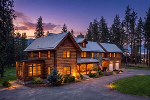 A large log cabin with a metal roof, multiple windows, and a covered porch. - Ninemile Creek Cabin: Fish in back yard, Hot Tub (Huson)