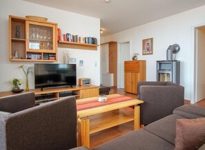 Een woonkamer met een televisie, bank en een boekenkast.