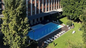 Ein Hotel mit Schwimmbad, Außenbereich und einem großen Gebäude mit rotem Dach.