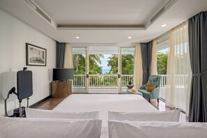 Ein Hotelzimmer mit Balkon, Fernseher, Schreibtisch und Stuhl.