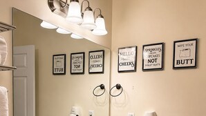 Ein Badezimmer mit einem großen Spiegel, einem Waschbecken und einem an der Wand befestigten Föhn.