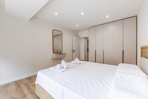 Une chambre à coucher avec un grand lit, un miroir et une armoire.