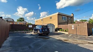 A gated driveway leading to a building with a garage. - The Modern Loft & Patio (Waukegan)