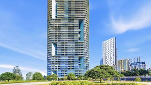 Um edifício moderno com fachada curva, várias sacadas e céu limpo.