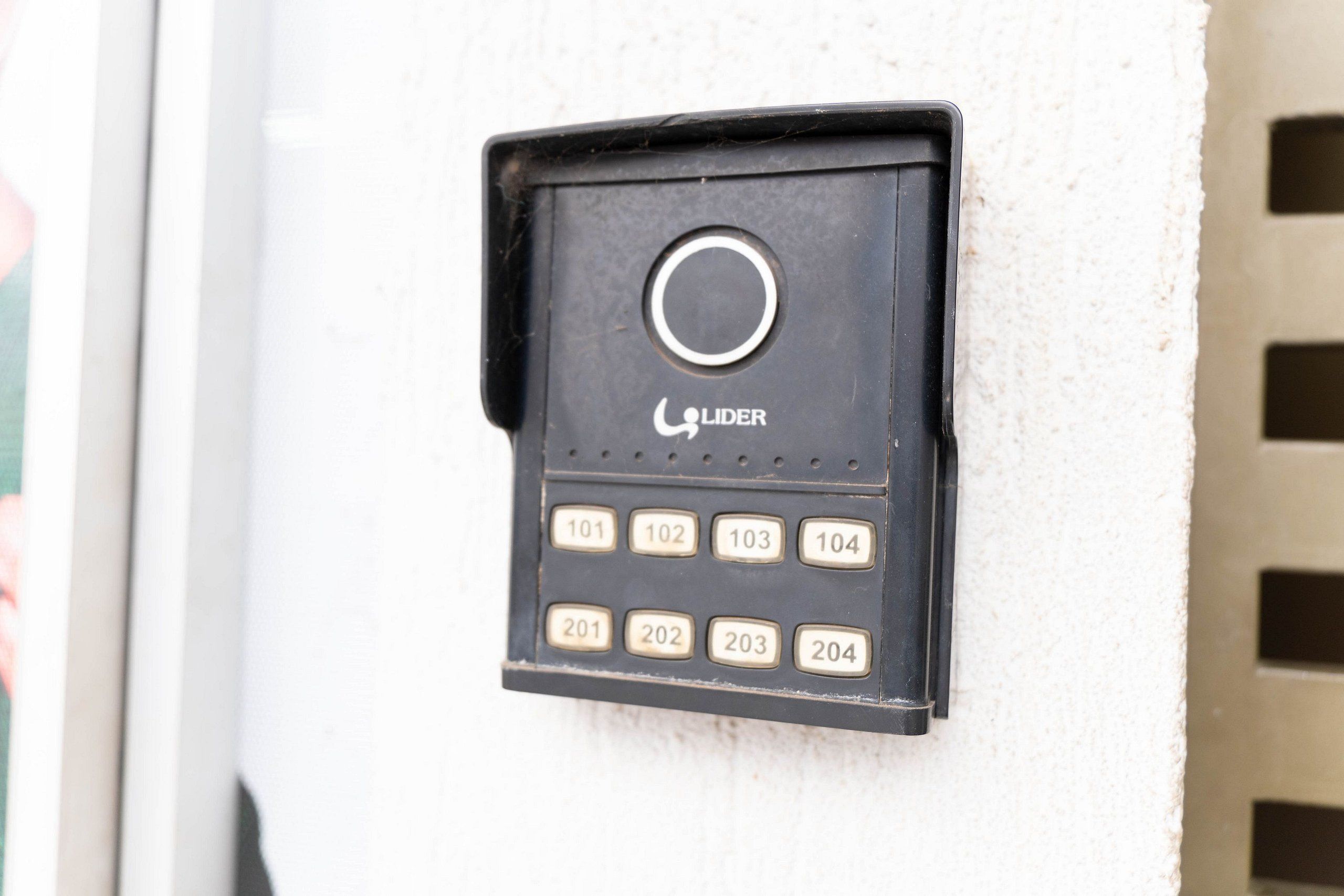 Un timbre negro con un botón circular y teclas numeradas para una cerradura de puerta.