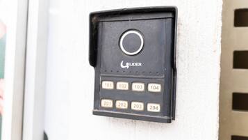 Un timbre negro con un botón circular y teclas numeradas para una cerradura de puerta.