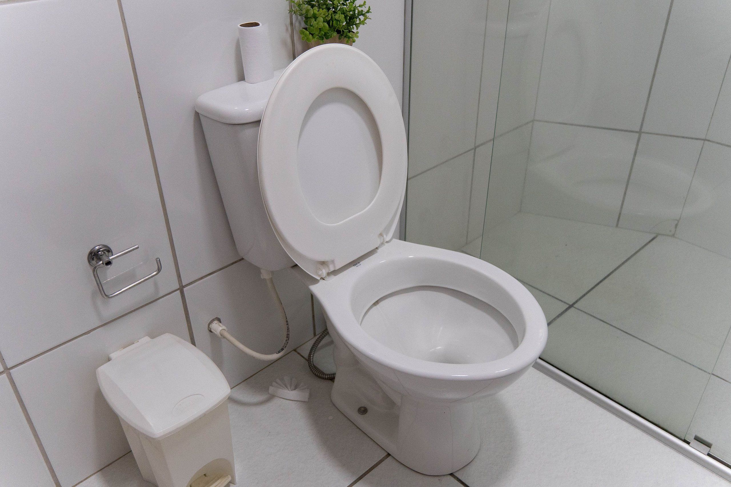 A modern bathroom with a toilet, bidet, and hand dryer.