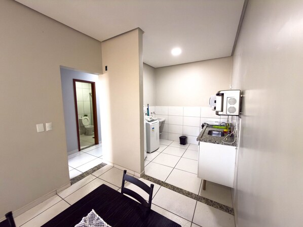 A compact kitchen with a sink, countertop, and a small trash bin. - CONDOMINIO SONHARE - 101 (ANAPOLIS)
