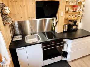 Una cucina moderna con un lavello doppio, elettrodomestici in acciaio inossidabile e una macchina per il caffè.