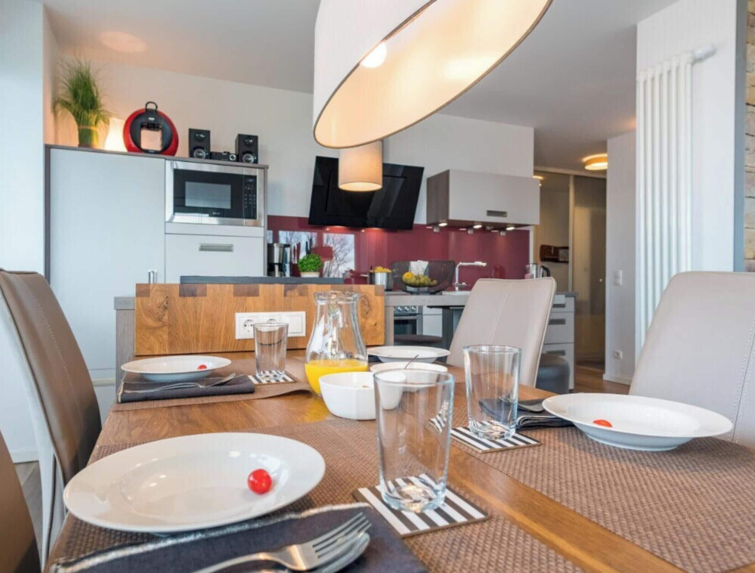 Une cuisine moderne avec un coin repas aménagé pour deux personnes.