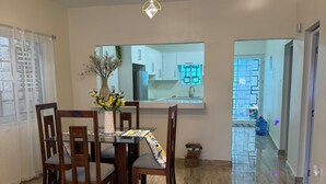 Un coin repas avec une table, des chaises et un vase de fleurs.