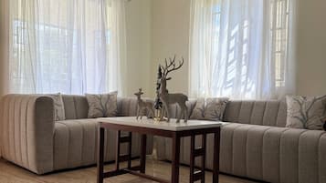 A living room with a sectional sofa, a wooden coffee table, and a decorative deer statue.