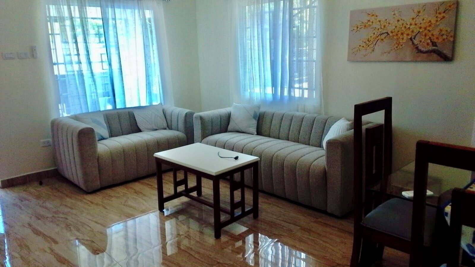 Una sala de estar con un sofá modular, una mesita y una silla.
