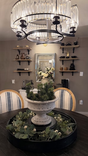A dining area with a chandelier, a central floral arrangement, and shelves with kitchenware. - Beautiful, Cozy, and Quiet Apartment in Coyoacán, Mexico City (Ciudad de México)