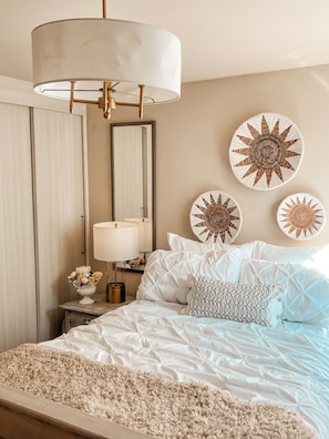 A bedroom with a bed, bedside table, lamp, mirror, and decorative wall art. - Beautiful, Cozy, and Quiet Apartment in Coyoacán, Mexico City (Ciudad de México)