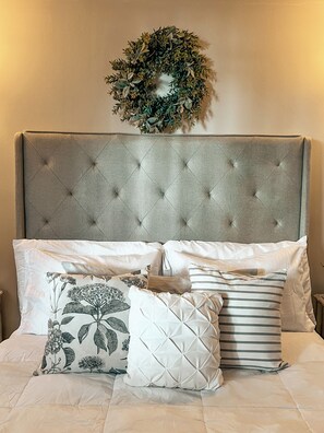A bed with a tufted headboard, multiple pillows, and a decorative wreath on the wall. - Beautiful, Cozy, and Quiet Apartment in Coyoacán, Mexico City (Ciudad de México)