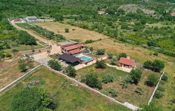 Un barrio residencial con varias casas, una piscina y un patio cercado.