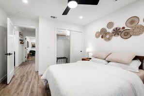 Una camera da letto con un letto, comodino, lampada e decorazioni a parete.