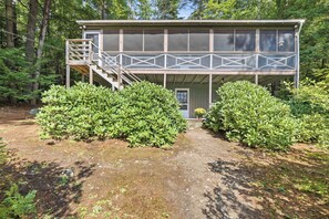 A two-story wooden cabin with a covered porch and a staircase leading to the upper level. - Center Harbor Lake Escape | Private Dock (Center Harbor)