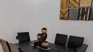 Una zona de menjador amb taula de fusta fosca, sis caires i un centre decoratiu.