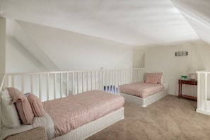 Ein Schlafzimmer mit zwei Einzelbetten, einem kleinen Nachttisch und einem Beistelltisch.