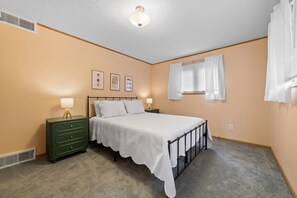 A bedroom with a single bed, a nightstand, a dresser, and a ceiling fan. - Loonar Landing: (Cheboygan)  Lakefront on Long Lake, Sleeps 8 (Cheboygan)