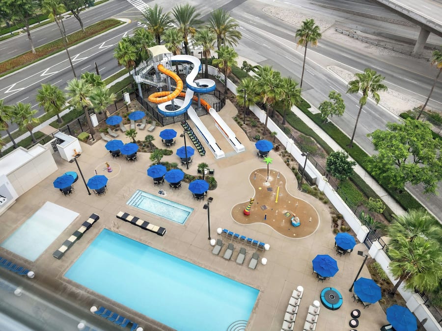A resort with a pool, lounge area, and water slides.