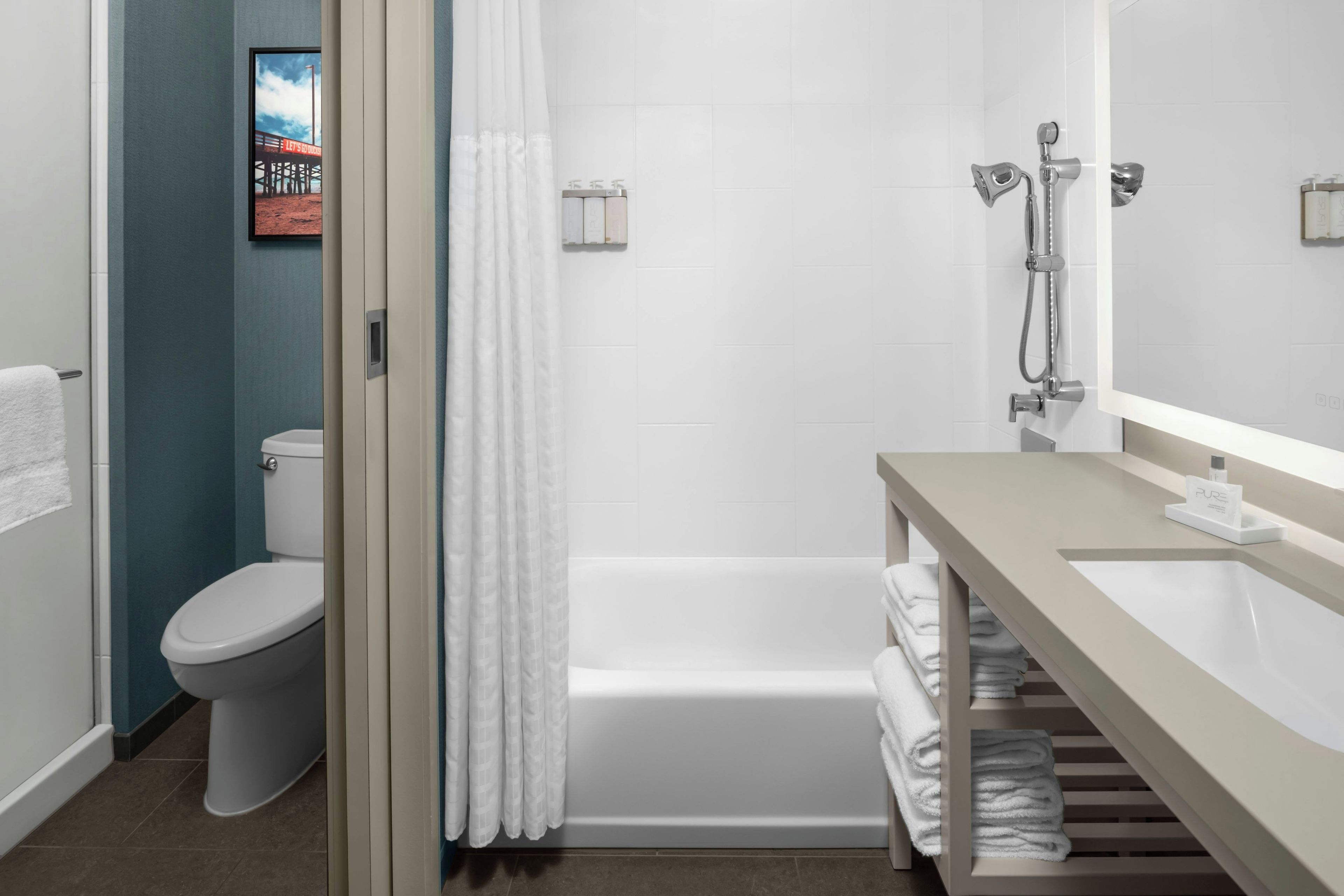 A modern bathroom with a toilet, bathtub, and shower.