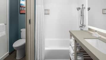 A modern bathroom with a toilet, bathtub, and shower.