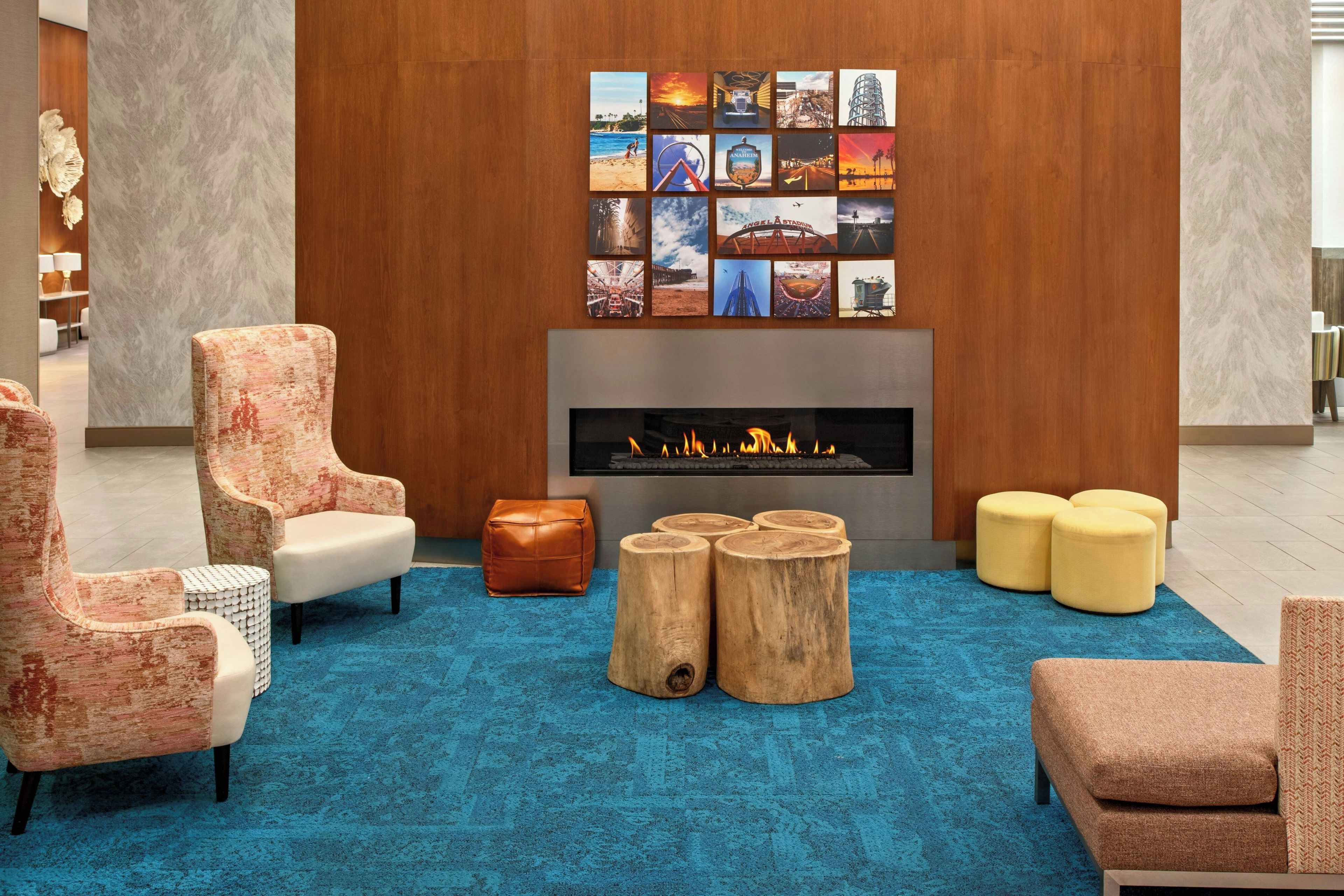 Un área de descanso moderna con chimenea, asientos y una pared decorada con diversas fotografías.