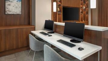 A hotel reception desk with two computer monitors, a keyboard, and a mouse.
