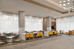 A hotel lobby with a seating area, a television, and a reception desk. - Springhill Suites By Marriott Anaheim Theme Park / Convention Area (Anaheim)