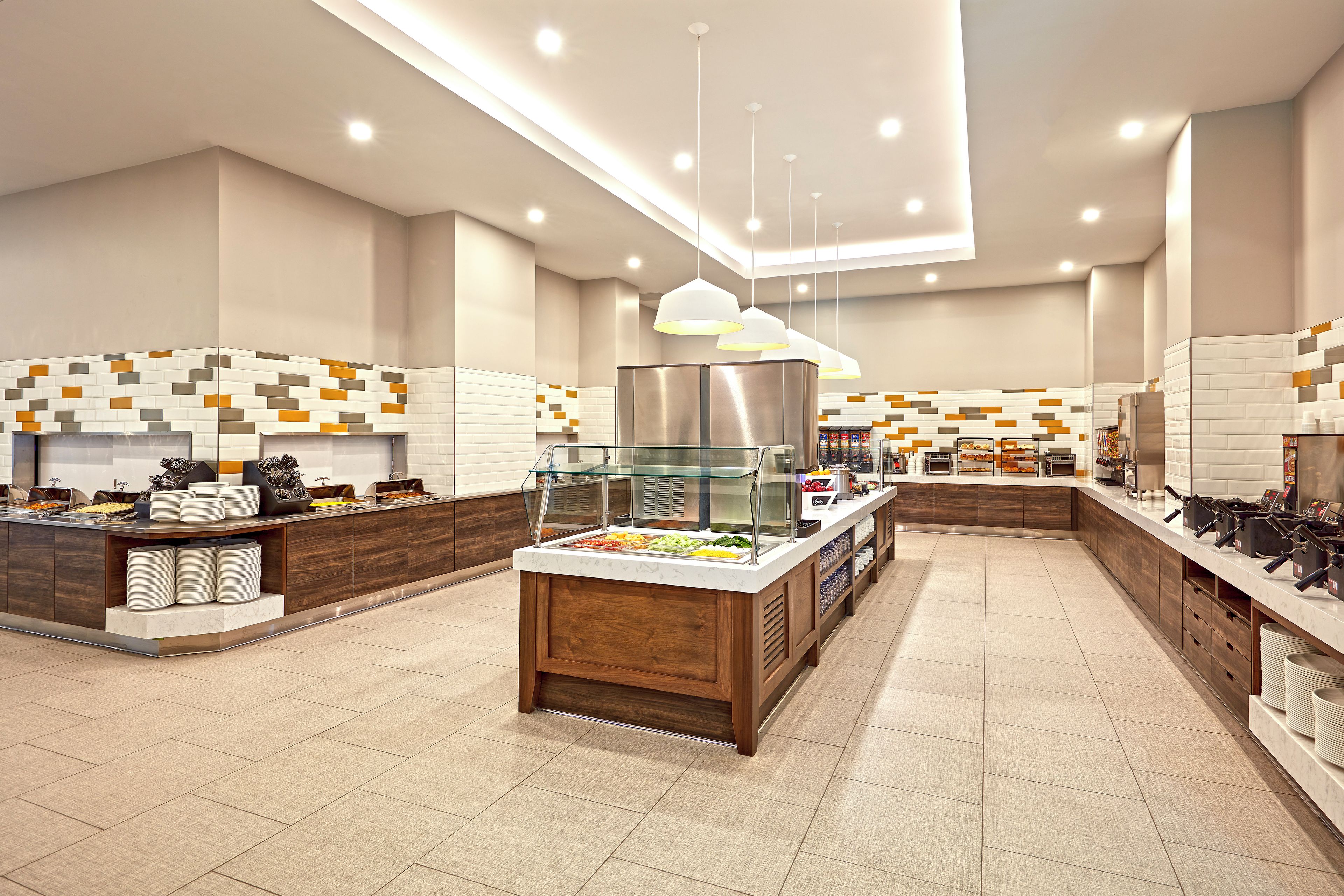 Una presentación de buffet moderna, con una zona central de servicio, varias estaciones de comida y un diseño limpio y contemporáneo.