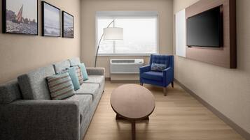A modern living room with a grey sofa, blue armchair, and a round coffee table.