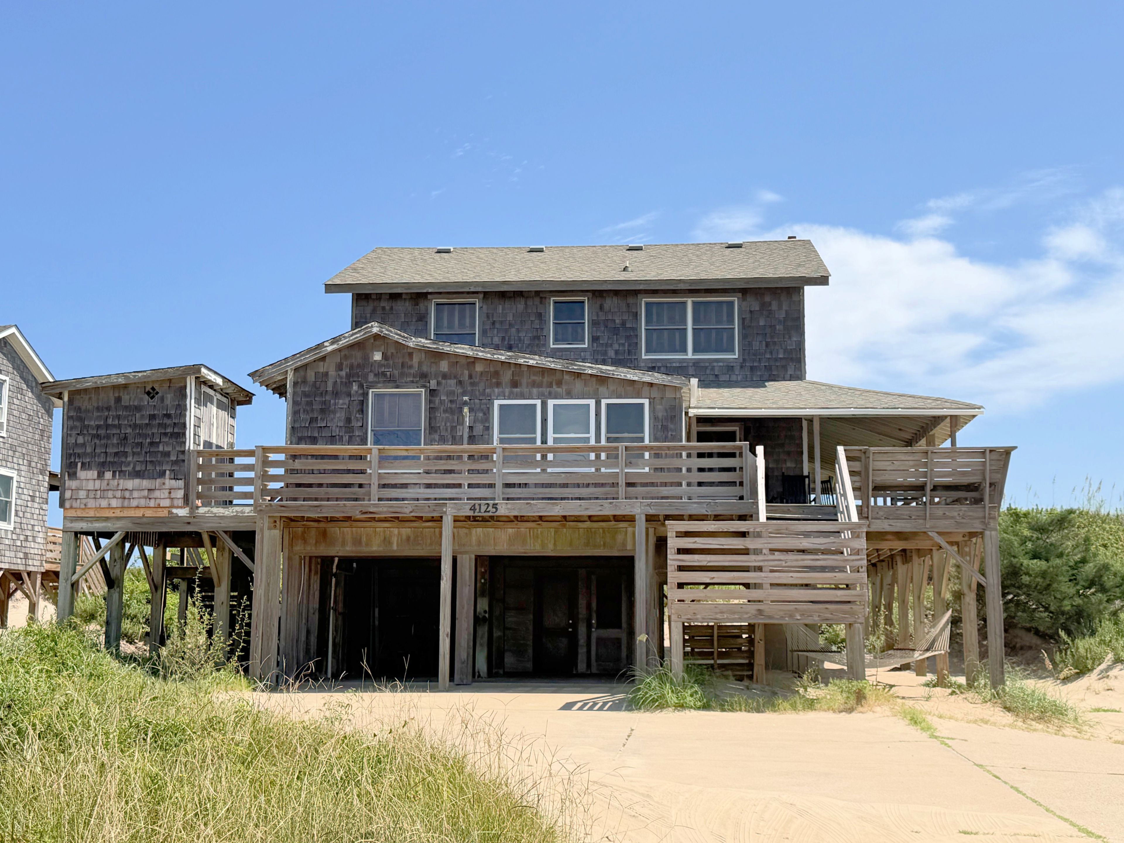 Ein zweigeschossiges Holzhaus mit Balkon und überdachter Veranda.