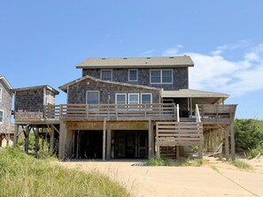 Ein zweigeschossiges Holzhaus mit Balkon und überdachter Veranda.