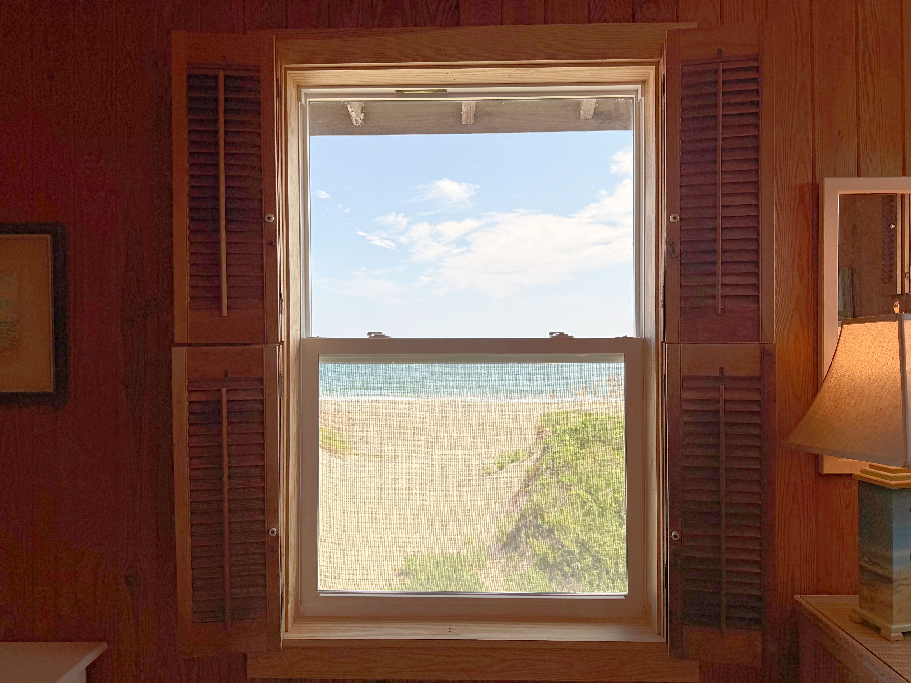 Una ventana con vistas a la playa y al océano.