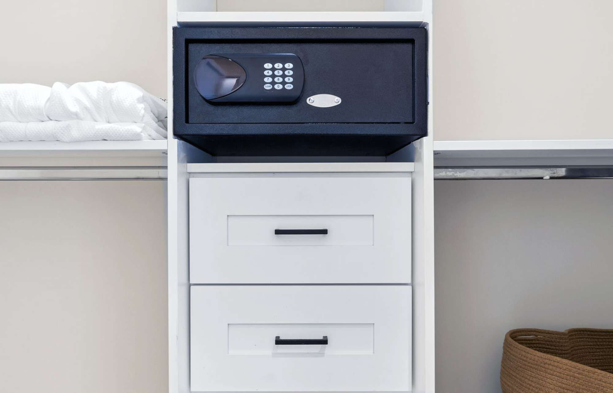 A white filing cabinet with a black safe on top.