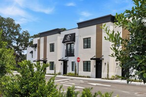 A modern hotel with a flat roof, a signboard, and a stop sign. - Cassa Hotel: Luxury Poolside 1BR/2BA Unit 101 (Orlando)